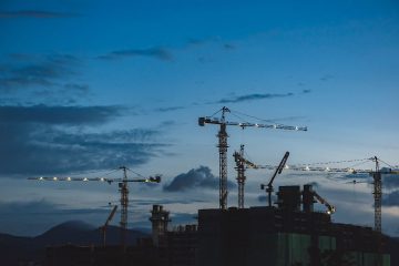 Grúas para construcción de viviendas de obra nueva en Valencia al atardecer